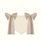 Beige decorative item with bows on a white background